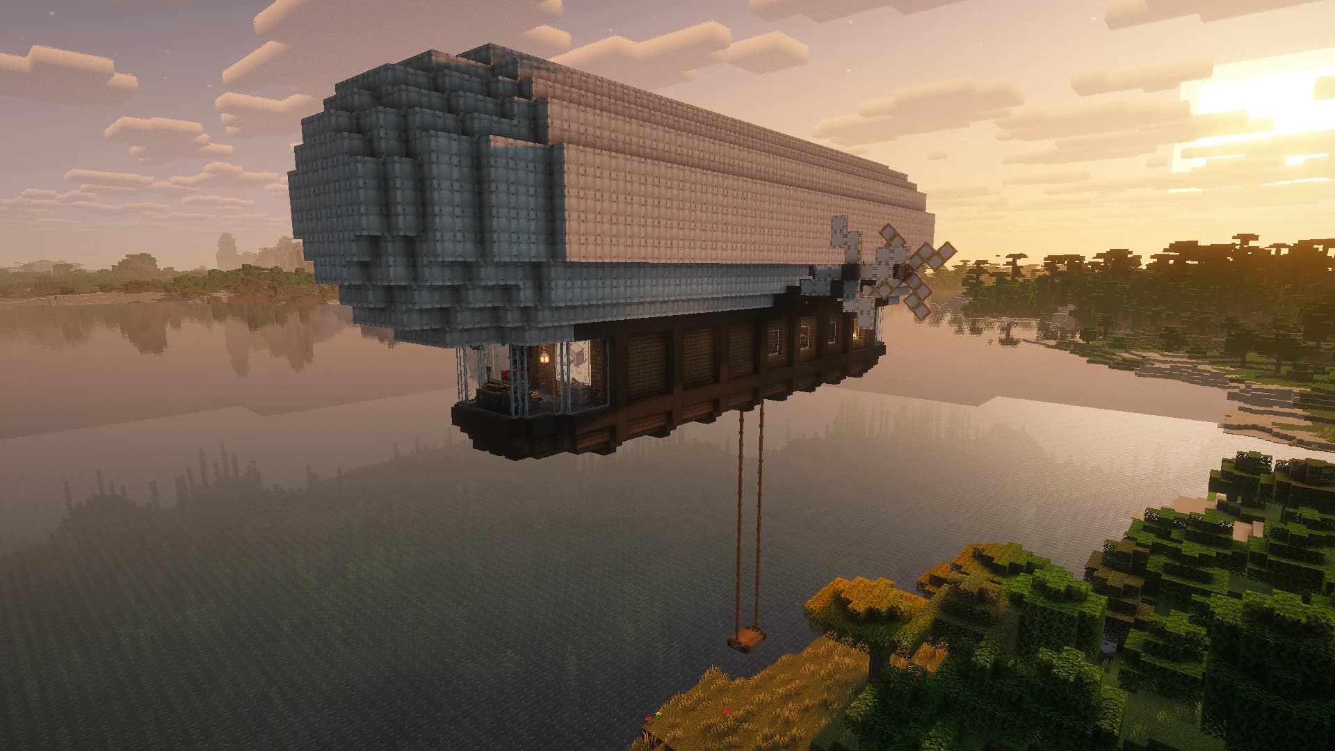 A Create Aeronautics airship above a lake at sunset